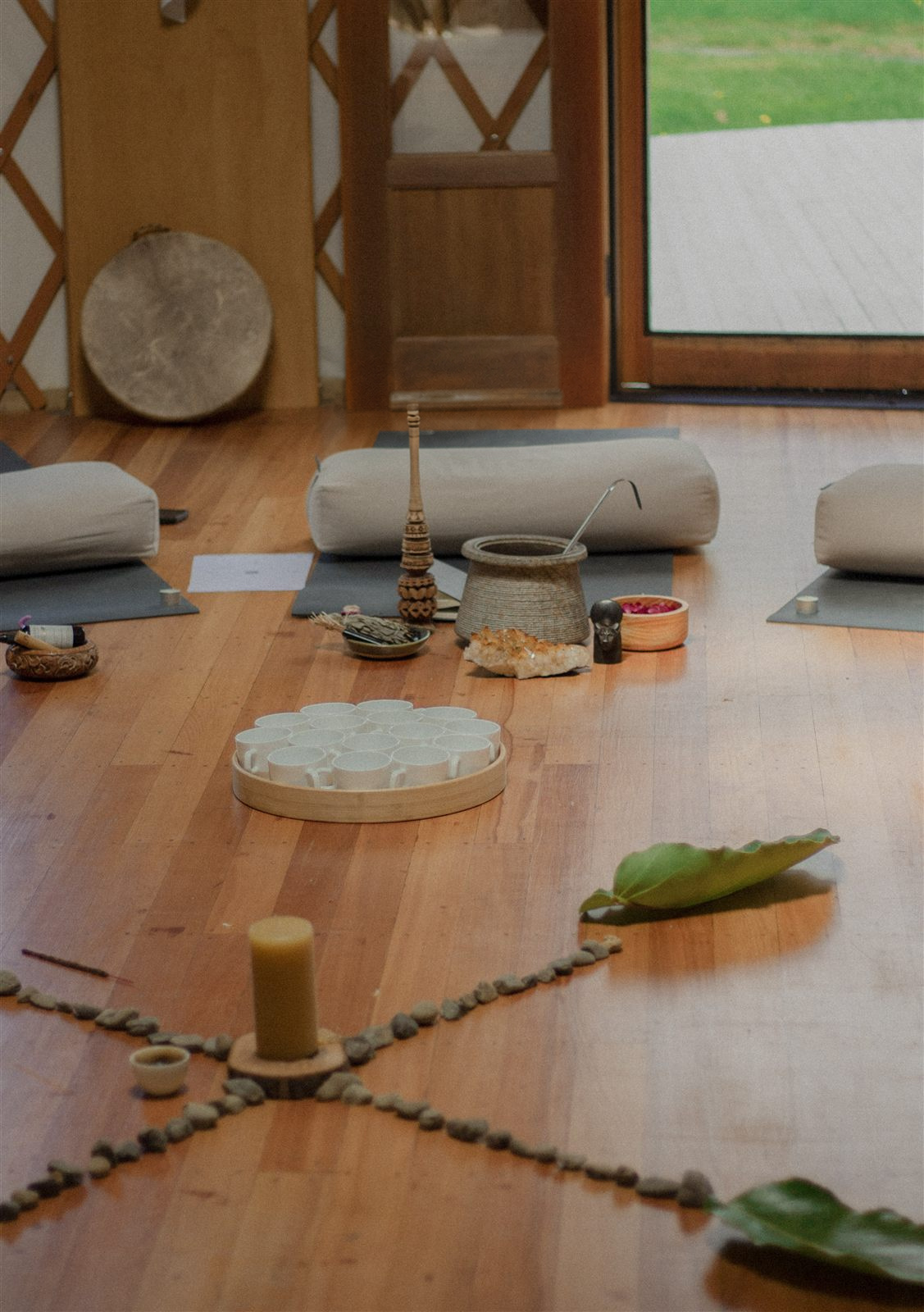A cacao ceremony altar Sofía set with stones, candle, shell cups and a hand drum