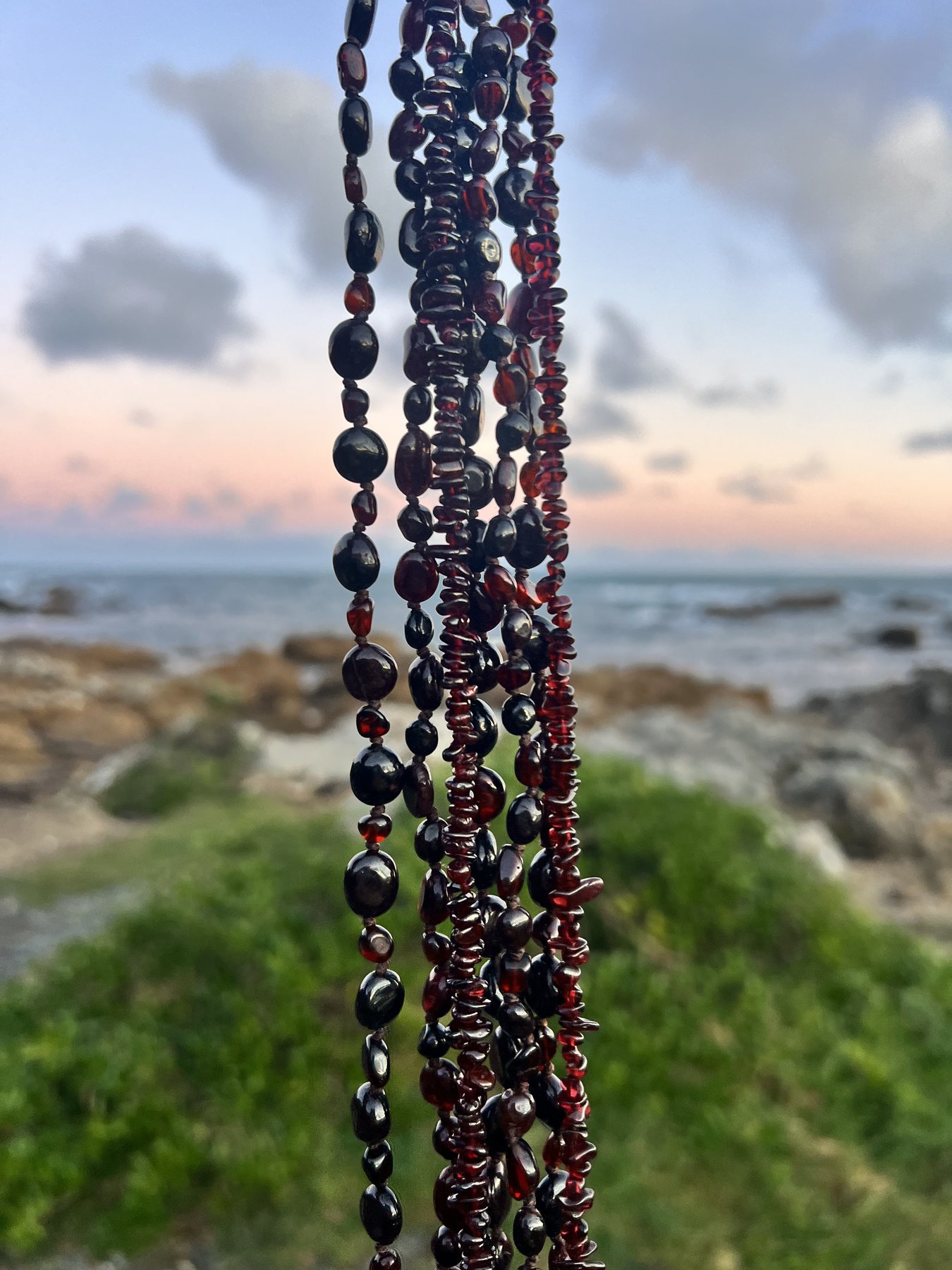 The Imbolc garnet adornments held together beside the sea at dusk