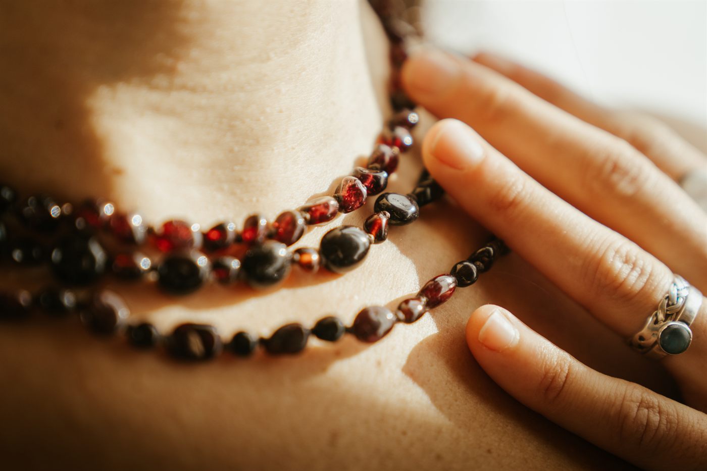 Three layered Moontime necklaces held close at the heart